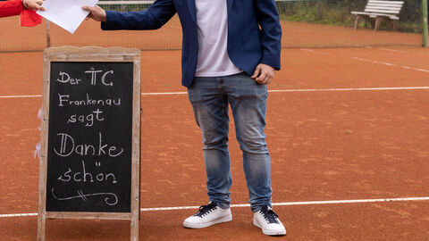 Bescheidübergabe auf Tennisplatz