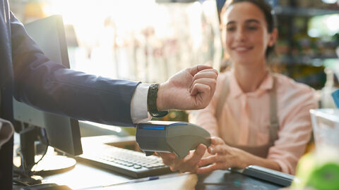 Mann bezahlt mit Smartwatch Mann bezahlt mit Smartwatch