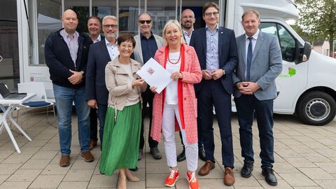 Digitalministerin Prof. Dr. Sinemus übergibt den Förderbescheid an die Bürgermeisterin von Bad Hersfeld, Anke Hofmann, sowie zahlreiche Bürgermeister als Vertreter der Partnerkommunen. Digitalministerin Prof. Dr. Sinemus übergibt den Förderbescheid an die Bürgermeisterin von Bad Hersfeld, Anke Hofmann, sowie zahlreiche Bürgermeister als Vertreter der Partnerkommunen.