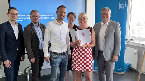 Digitalministerin Prof. Dr. Kristina Sinemus überreicht die Förderzusage über 733.500 Euro aus dem Programm „Starke Heimat Hessen“ Digitalministerin Prof. Dr. Kristina Sinemus hält die Förderzusage in der Hand. Neben ihr stehen rechts und links weitere Personen.