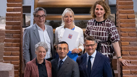 Mehrere Menschen stehen auf einer Treppe und schauen in Kamera