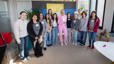 Teilnehmerinnen des Girls' Day stehen gemeinsam mit der Digitalministerin zum Gruppenfoto aufgestellt in einem Raum.