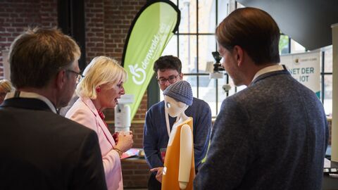 Digitale Städte – Digitale Regionen Frau spricht mit Roboter.