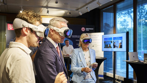 Drei Personen stehen nebeneinander und tragen eine VR-Brille.