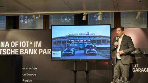 Ein Mann steht auf einer Bühne und hält ein Mikrofon in der Hand.