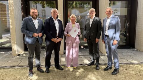 Dr. Sinemus steht mit vier Männern in einer Reihe - sie hält einen Förderbescheid in den Händen.