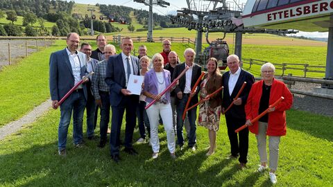 Gigabitförderung Willingen Digitalministerin Sinemus steht mit einer größeren Personengruppe auf einer Wiese vor einem Lift.