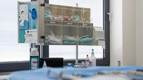 Medizinische Produkte in Behältern. Zu sehen sind zum Beispiel Handschuhe und Spritzen