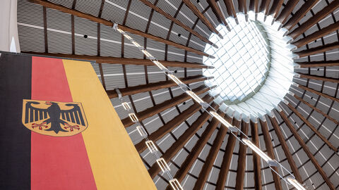 Deutsche Flagge hängt in einem Gebäude vom Dach.