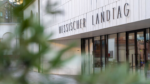 Aufnahme vom Eingangsbereich des hessischen Landtags. Zu sehen ist der Schriftzug "Hessischer Landtag"  über der Tür.